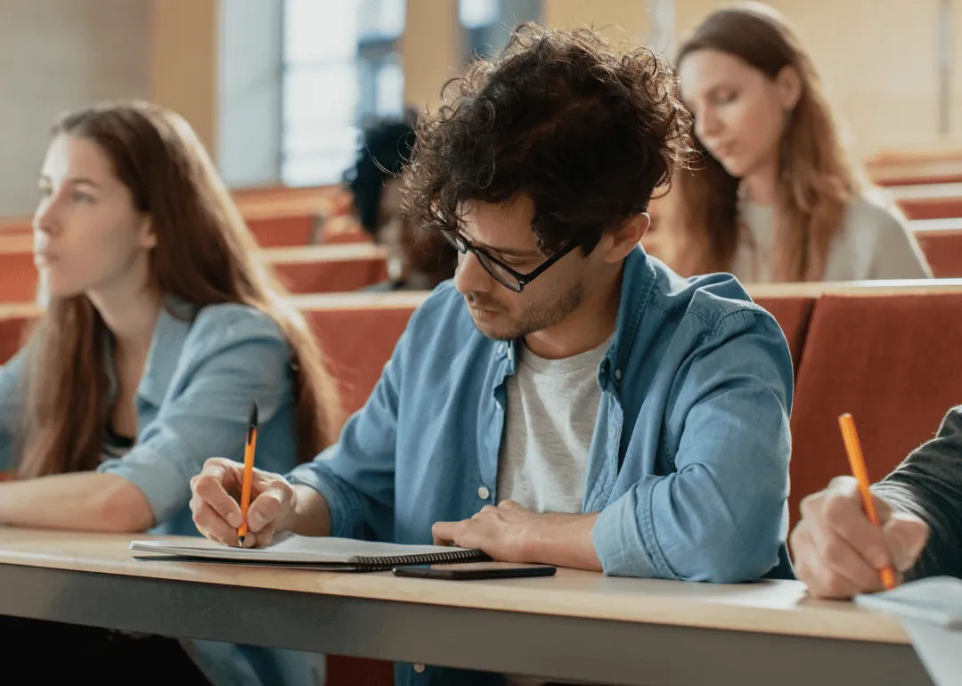 Ein Student, der mit einem Stift Notizen schreibt