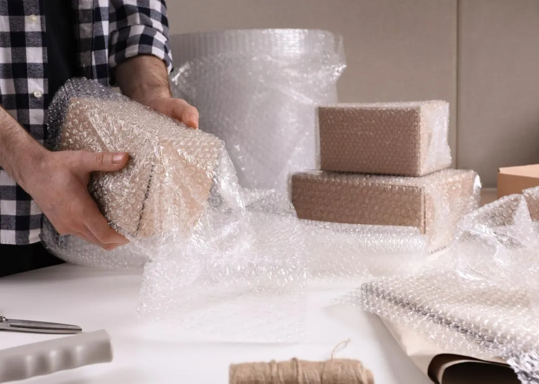 Une personne emballant une boîte avec du papier bulle