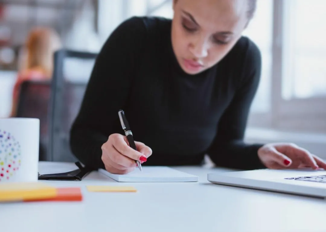 Eine Frau schreibt auf einen Notepad